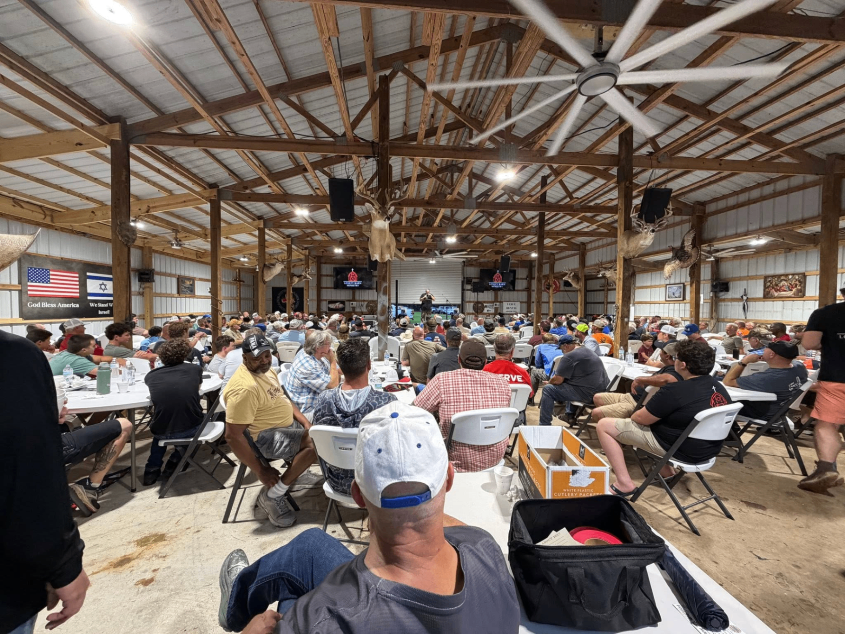 Wide interior view of The Loxley Barn packed with men around tables