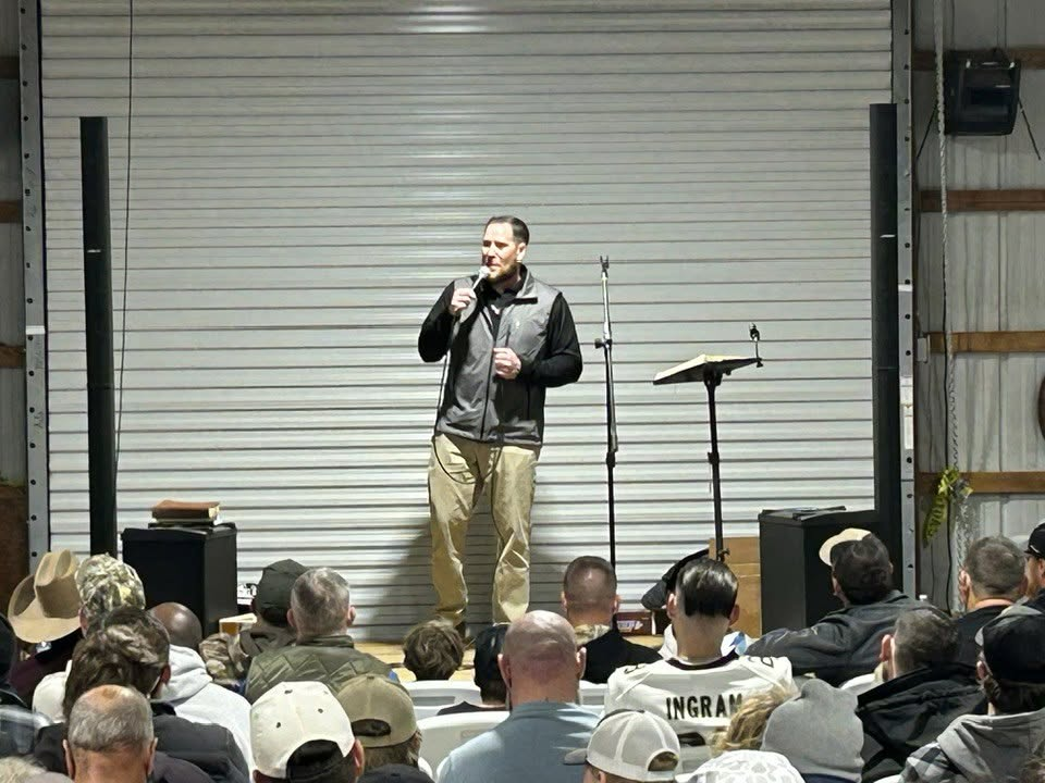 Speaker sharing a message from the stage at The Loxley Barn