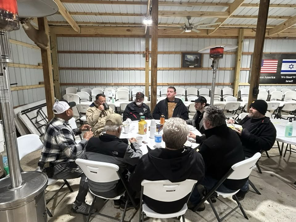 Men gathered around a table talking after the meal